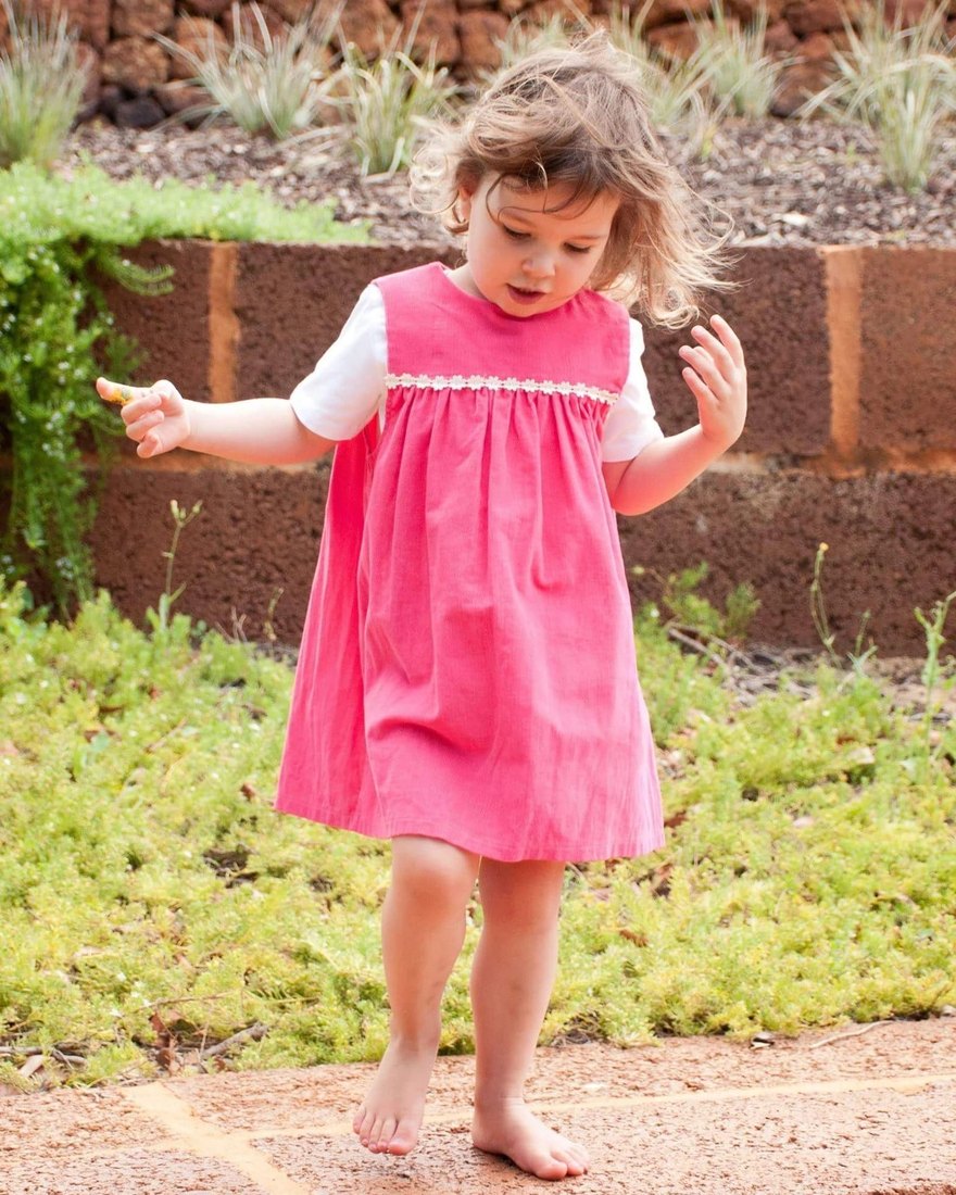 A young child playing outdoors in a garden